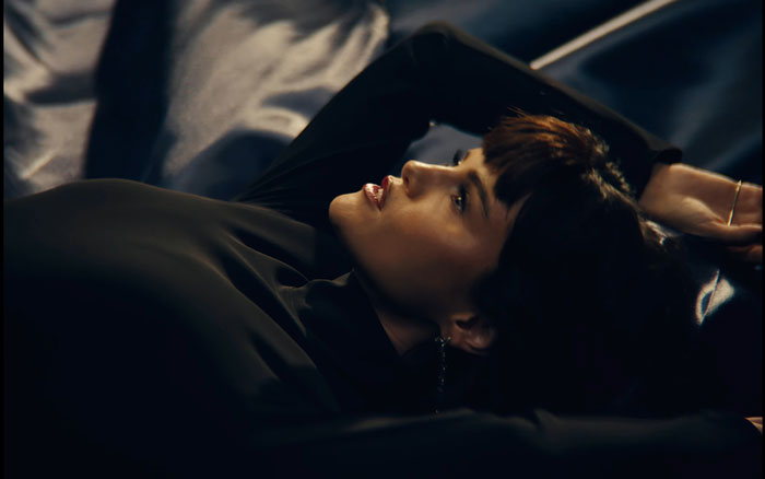 Selena Gomez lying down with a dramatic expression in a dark setting from her new music video that shocked fans. Selena Gomez lying down with a dramatic expression in a dark setting from her new music video that shocked fans.