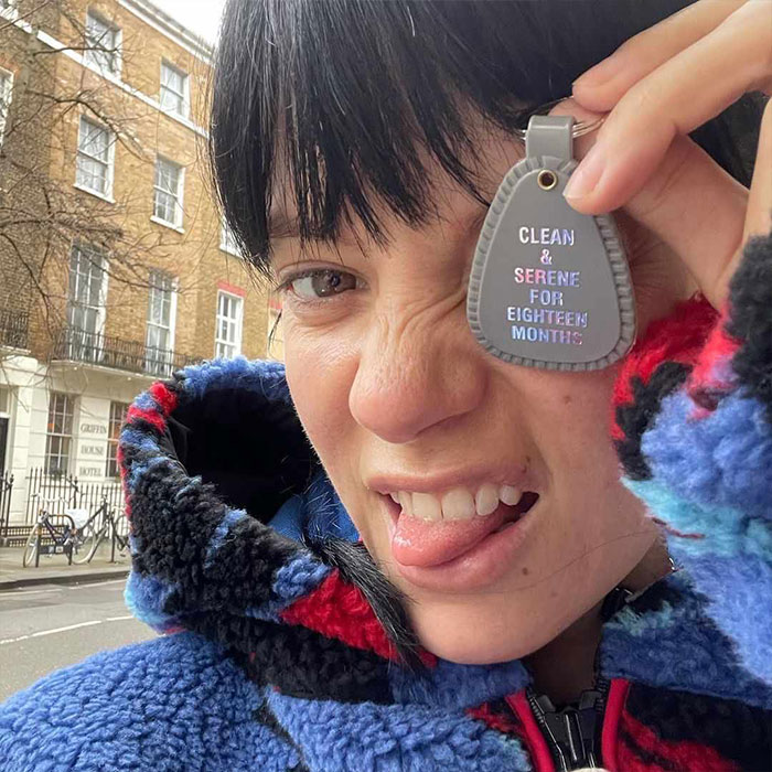 Lily Allen making a playful face outdoors, holding a keychain, highlighting new album and disturbing cheating claims.