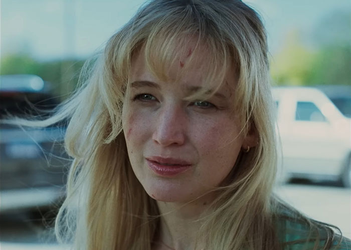 Jennifer Lawrence outdoors with natural makeup, addressing plastic surgery plans after viral video reaction from fans.