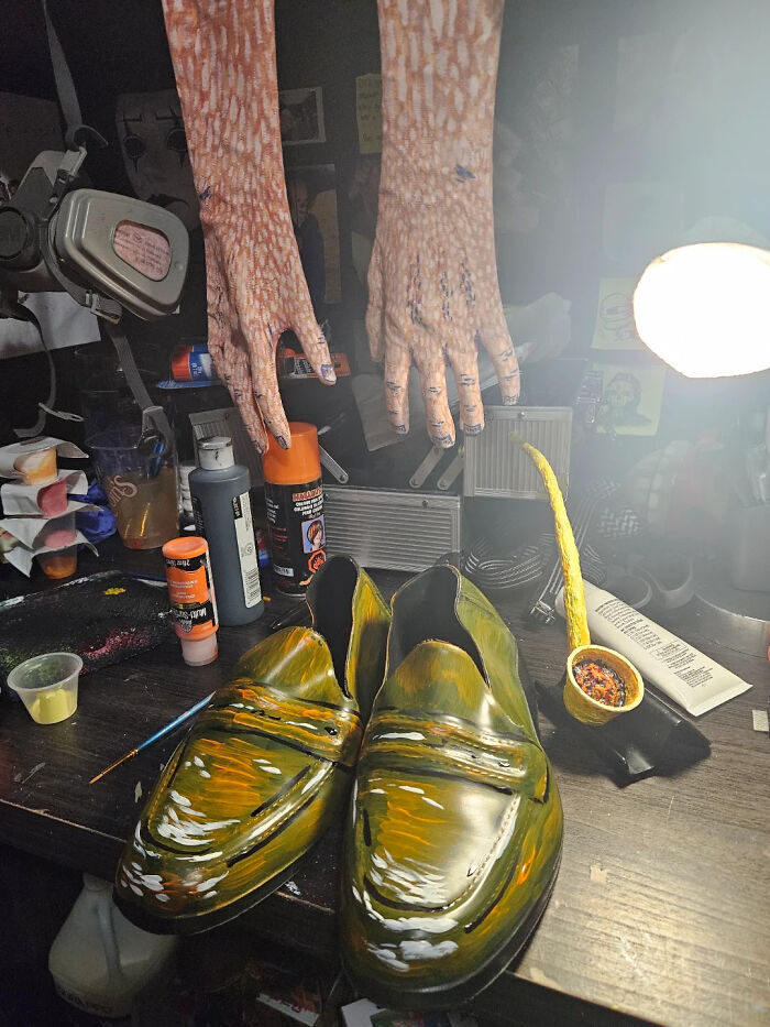 Hand-painted shoes and detailed makeup hands on a table as part of an artist's Vincent van Gogh Halloween costume.