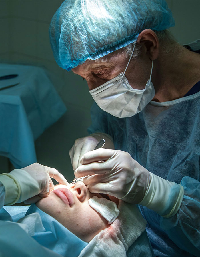 Surgeon performing delicate eye surgery on patient in sterile operating room, highlighting risks of eye color change.