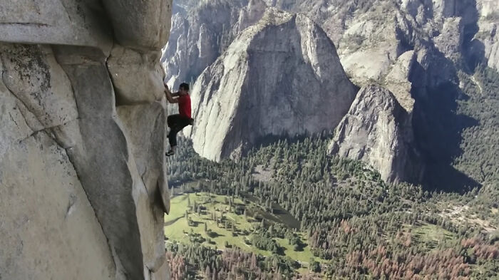 A climber scaling a steep rock face in a mountainous park, showcasing an impossible true story movie scene.