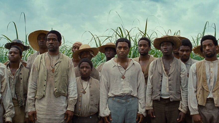 A group of men in historical clothing standing in a field, scene from movies based on true stories.