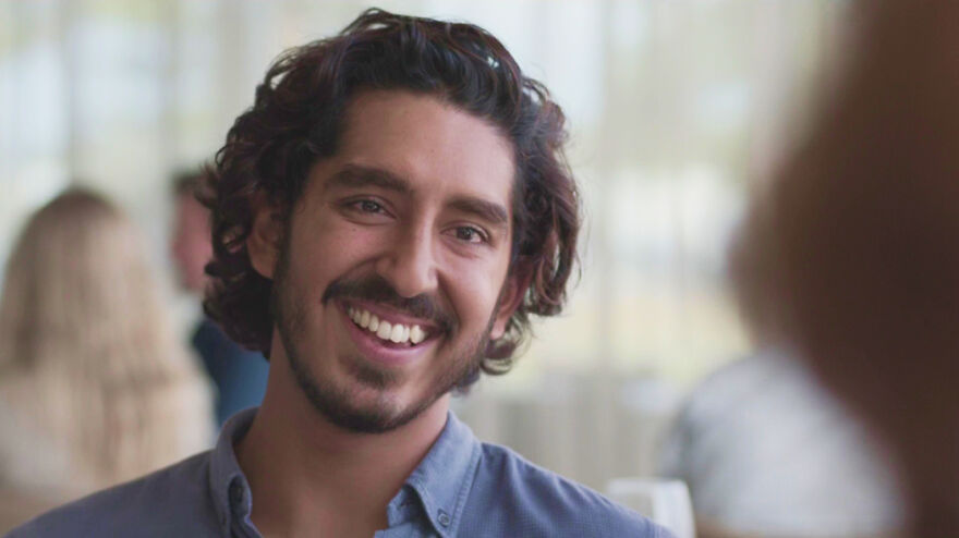 Man with curly hair smiling in a bright setting, a scene from a movie based on true stories that feel impossible to believe