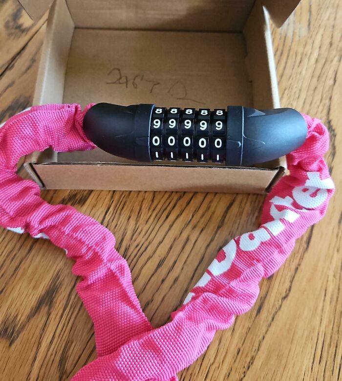 Pink chain lock with combination dial on a wooden surface, showing a humorous take on sensible adults.