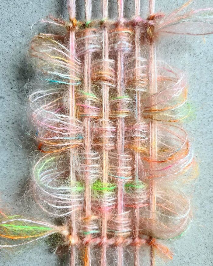 Close-up of colorful threads woven in a mesmerizing textile creation showcasing intricate arts and fibers.