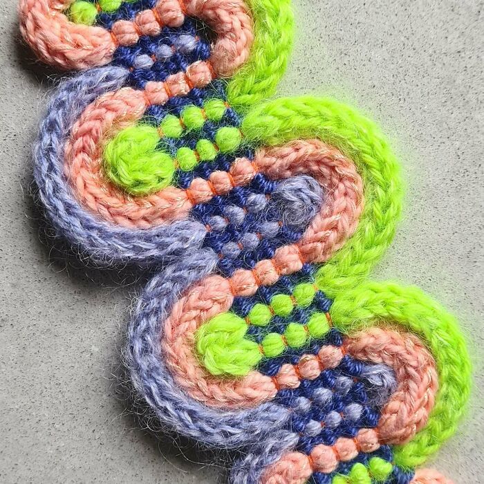 Close-up of colorful textile creation showcasing vibrant threads woven into a mesmerizing artistic pattern.