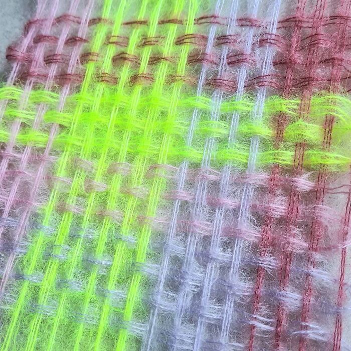Close-up of colorful textile threads woven tightly, showcasing mesmerizing craftsmanship in vibrant yarns and fibers.