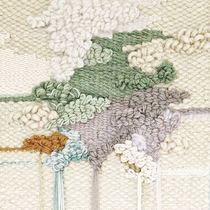 Close-up of mesmerizing textile creation showing detailed woven and knotted threads in muted green, lavender, and cream colors.
