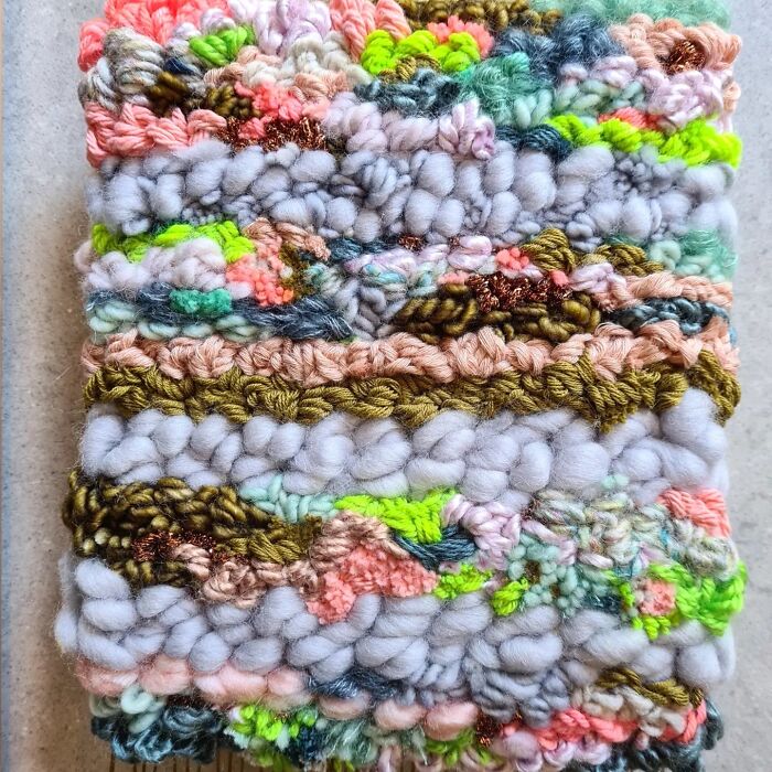 Close-up of colorful textured textile creation showcasing intricate threads and artistic weaving techniques.