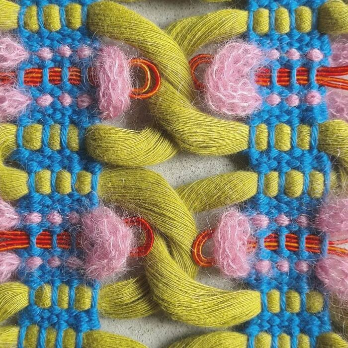 Close-up of colorful threads woven into an intricate and mesmerizing textile creation showcasing artistic craftsmanship.