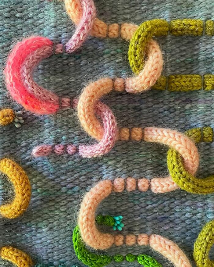 Colorful yarn threads woven into mesmerizing textile chains, showcasing intricate and artistic fabric creations by an innovative artist.