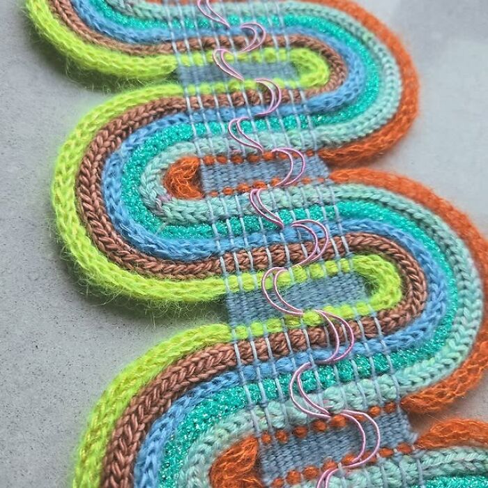 Colorful textile creation with woven threads in a mesmerizing pattern showcasing intricate artistic craftsmanship.
