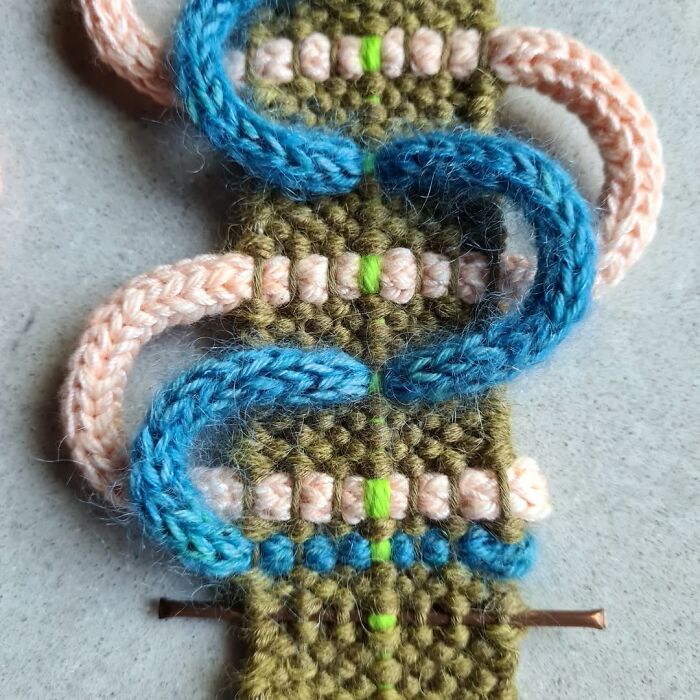 Close-up of mesmerizing textile creation with colorful crocheted threads forming intricate patterns on fabric.