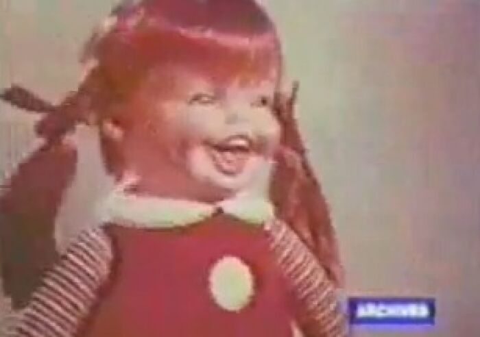 Creepy doll with red hair and striped sleeves from a vintage commercial that might give you nightmares.