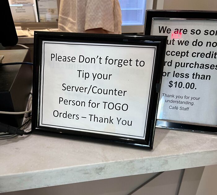 Sign on counter asking customers to tip their server or counter person for to-go orders, illustrating people allergic to acting sensible.