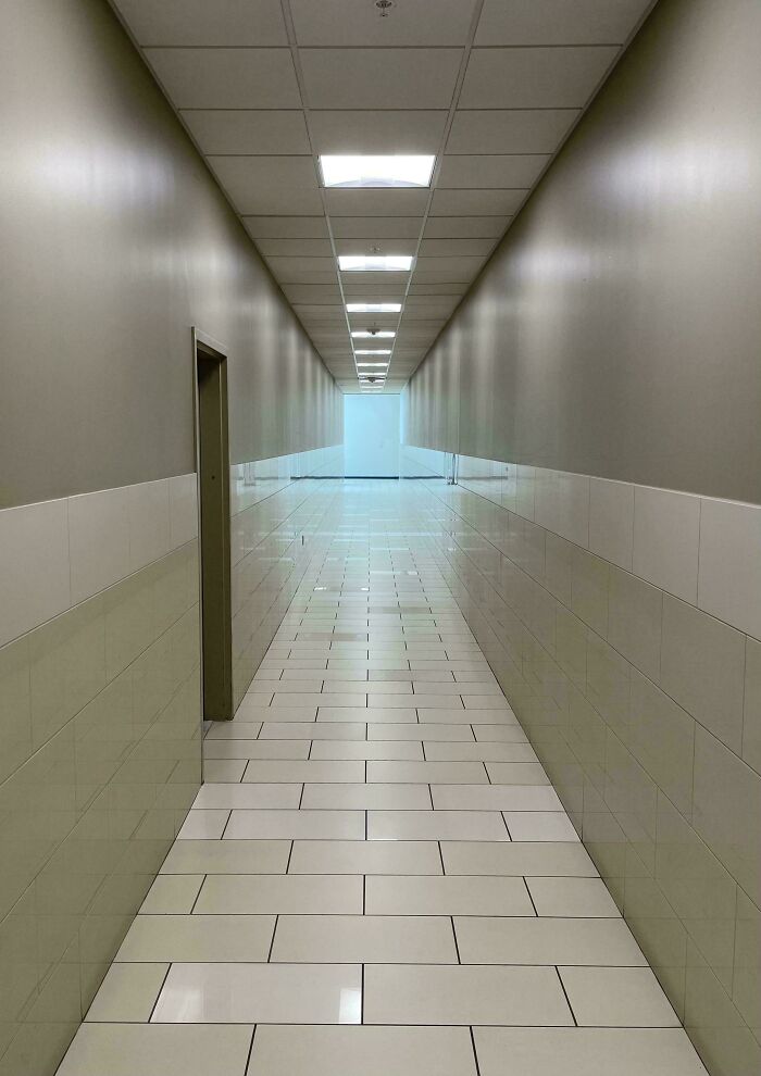 Unphotoshopped corridor photo with reflective tiles and walls creating an optical illusion that looks fake but is 100 percent real.