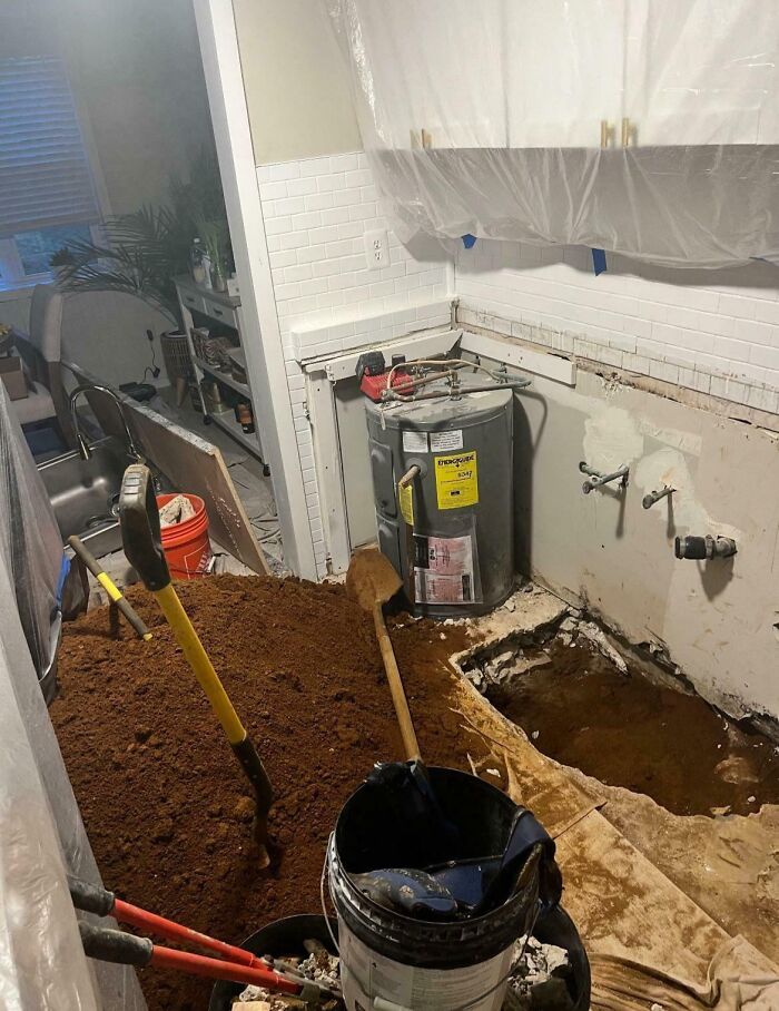 Kitchen renovation gone wrong with dirt, tools, and exposed water heater showing lack of sensible adult behavior.