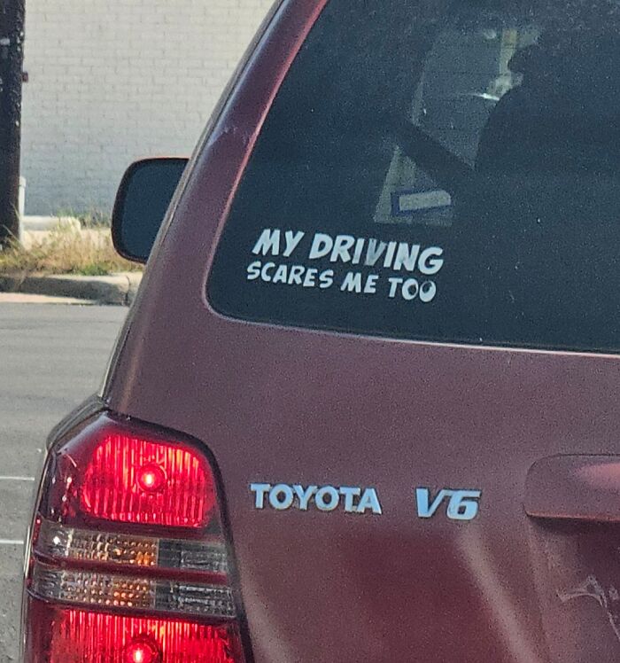 Clever and hilarious bumper sticker on a red Toyota V6 saying my driving scares me too seen on the road.
