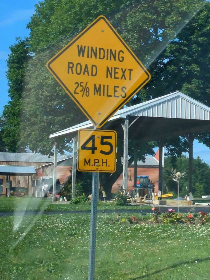 Yellow road signs indicating a winding road for 2 5/8 miles and a 45 mph speed limit causing potential confusion.