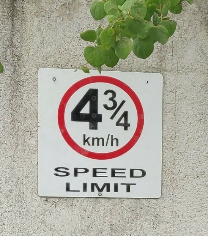 Unusual road sign showing a confusing speed limit of 4 3/4 km/h, highlighting confusing road signs.