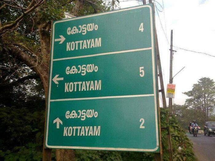 Confusing road sign showing three different directions and distances to Kottayam, causing traffic navigation issues.