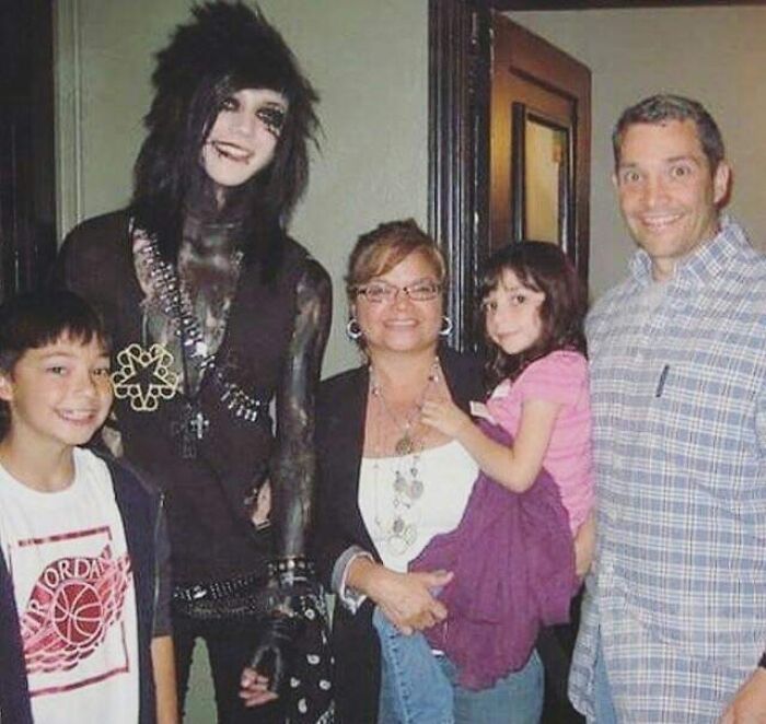 Family photo with contrasting styles shows a gothic teenager among smiling relatives, a moment often laughed or cringed at online.