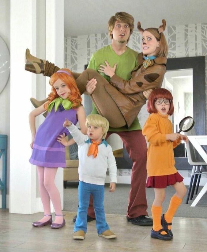 Familia disfrazada de Scooby-Doo en foto familiar incómoda con poses graciosas y expresiones divertidas.