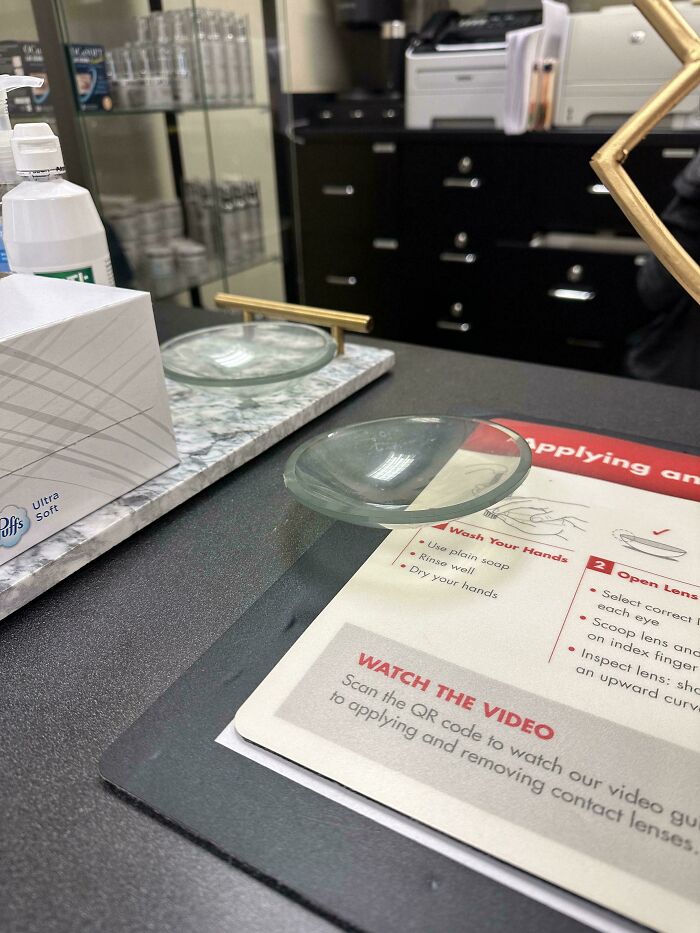 Contact lens on instructional guide with tissue box and hand sanitizer, a wholesome doctor gesture to ease patients.