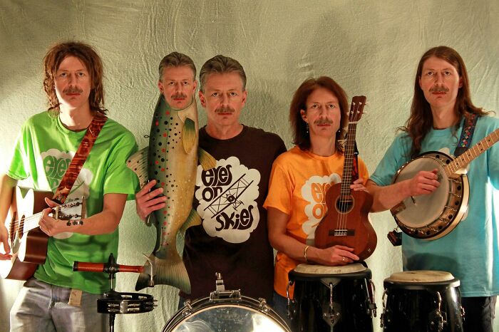 Group of men playing instruments in a family photo that ended up being laughed at and cringed online forever.