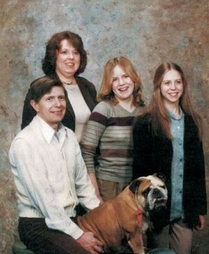 Family photo with a dog posing awkwardly, a classic example of family photos laughed at and cringed over online.