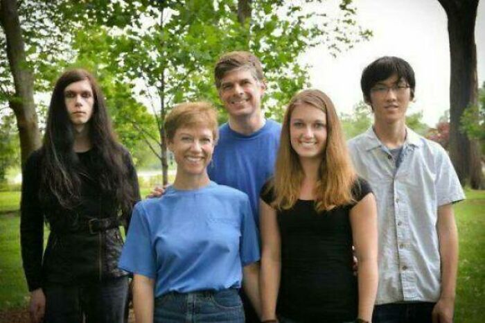 Family photo with five people in a park, showing a mix of expressions that could be laughed or cringed at online.