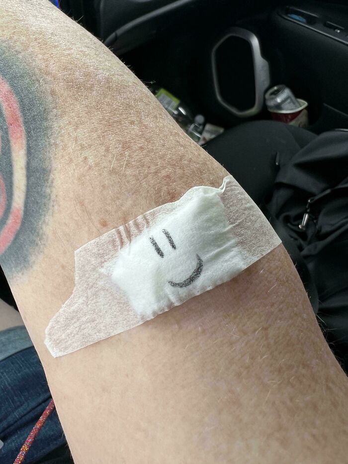 Patient's arm with a bandage featuring a smiley face, one of the hilarious and wholesome things doctors did to ease patients.