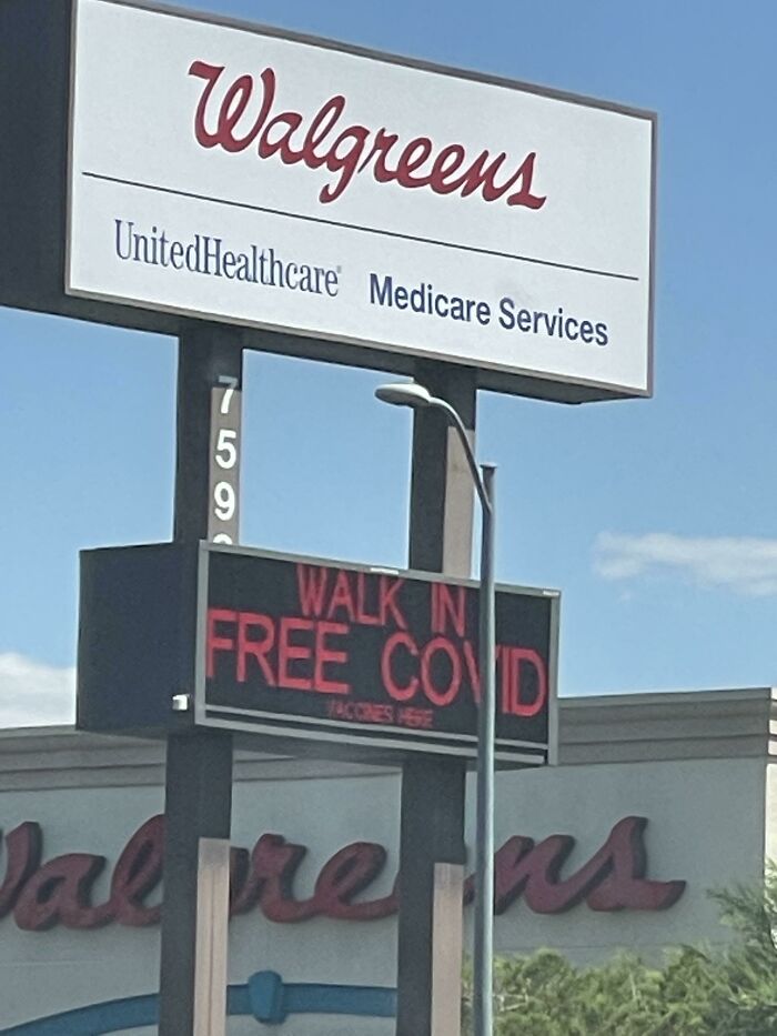 Walgreens billboard with a confusing message about free COVID walk-in vaccine services in a sunny outdoor setting.
