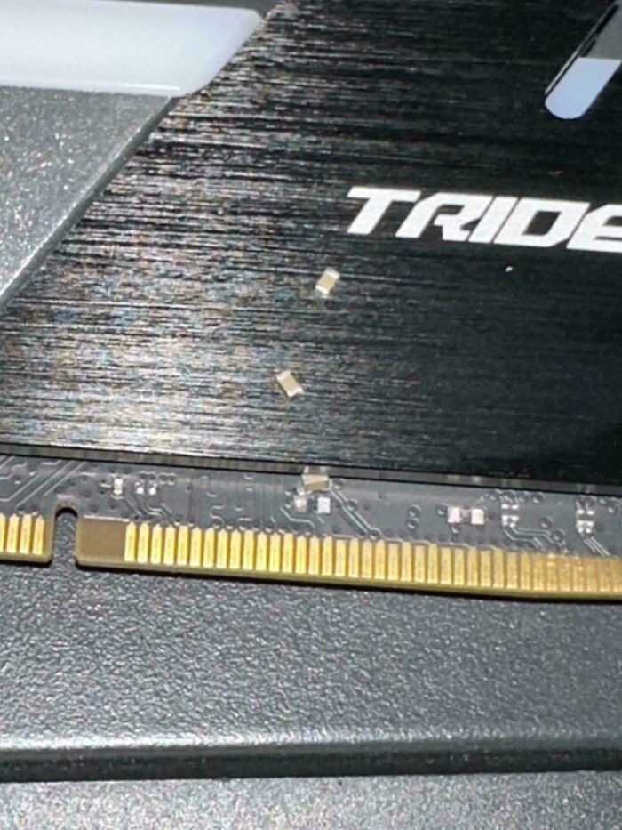 Close-up of broken electronic components on a circuit board, showing damaged parts and poor handling of electronics.