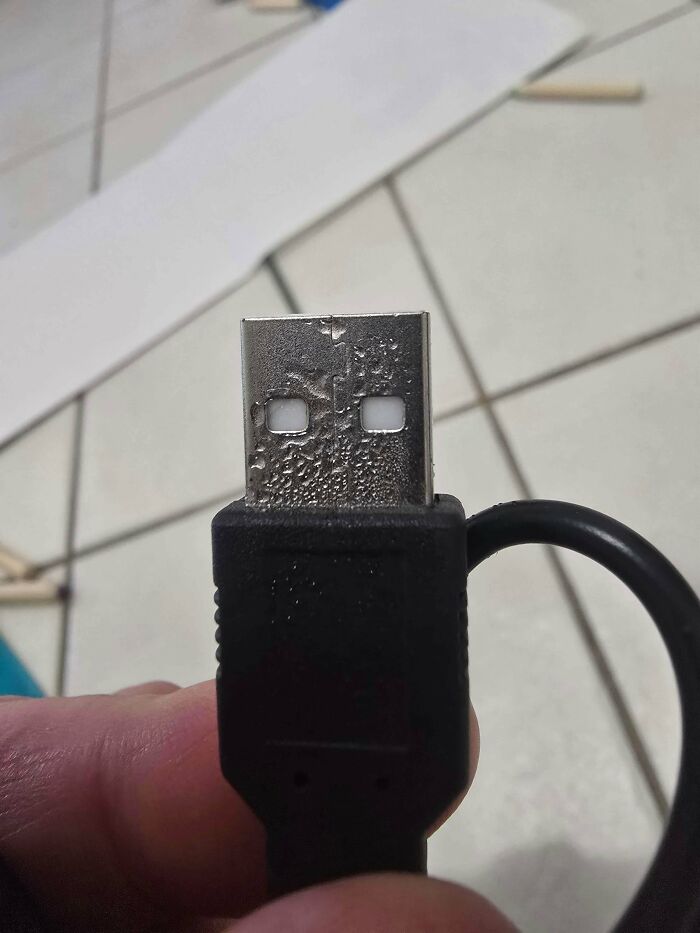 Close-up of a damaged USB connector with corrosion and wear, illustrating common electronics handling mistakes.