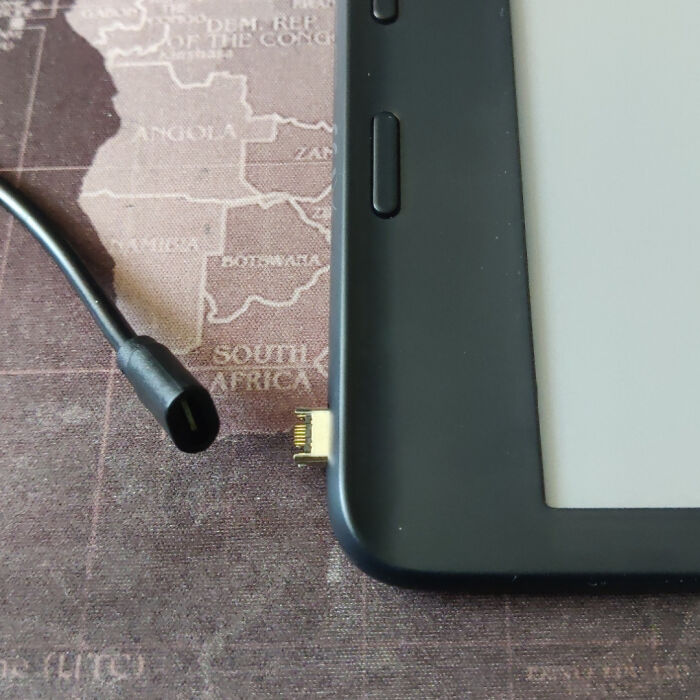 Close-up of a broken electronic device connector with a detached charging cable, illustrating electronics handled the wrong way.