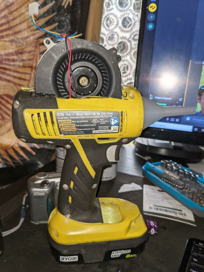 Yellow Ryobi cordless drill modified with exposed wires and a fan attached, showing a painful electronics handling mistake.