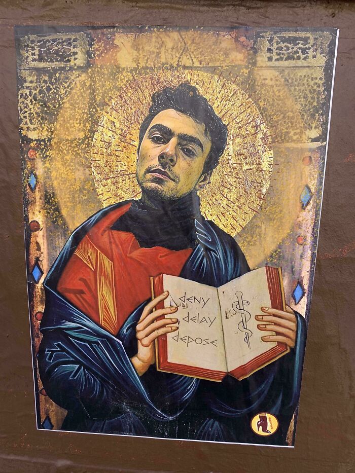 Street art depicting a man with a golden halo holding an open book, blending classical and modern styles.
