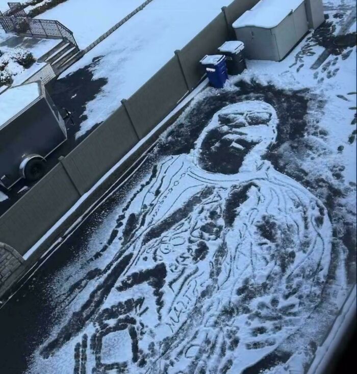 Street art portrait created in snow on pavement, showcasing beautiful and powerful street art from around the world.