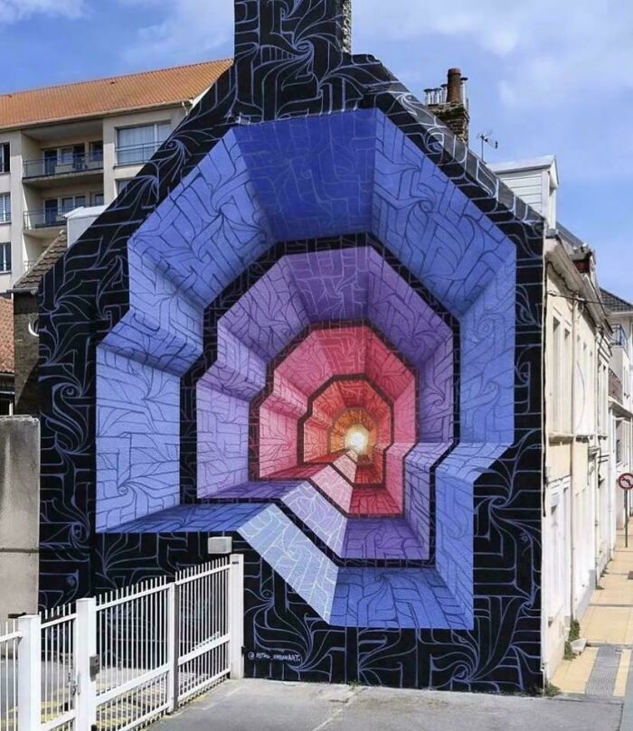 3D optical illusion street art painted on a building wall showcasing vibrant colors and intricate patterns in urban street art style.