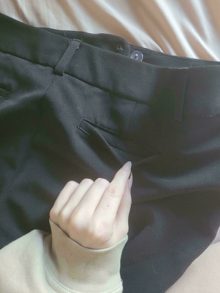 Hand trying to put fingers into a non-functional pants pocket, a mildly infuriating thing testing patience.