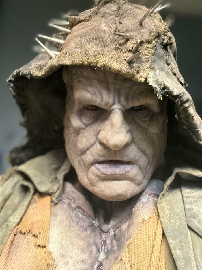 Close-up of a detailed Halloween costume featuring a creepy, weathered mask with a hood and spikes for genius Halloween costumes.