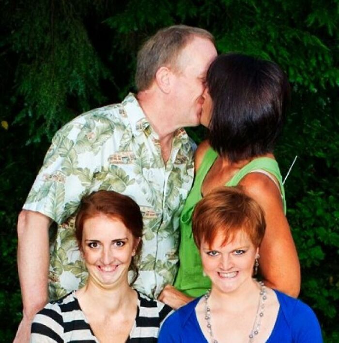 Pareja mayor besándose detrás de dos mujeres con expresiones cómicas en foto familiar incómoda y icónica.