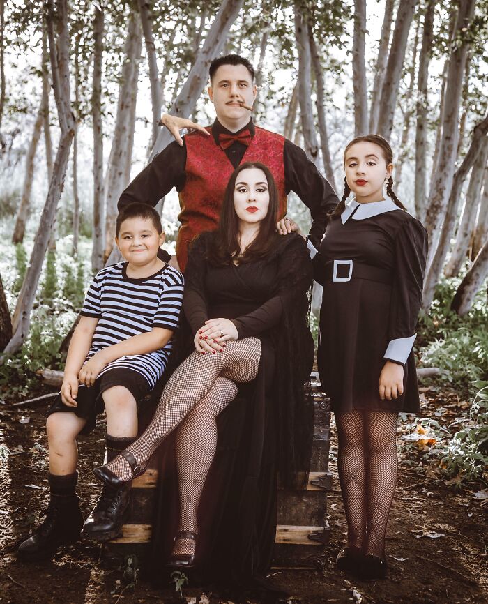 Foto familiar con disfraces temáticos y poses poco naturales creando una imagen familiar incómoda e icónica.