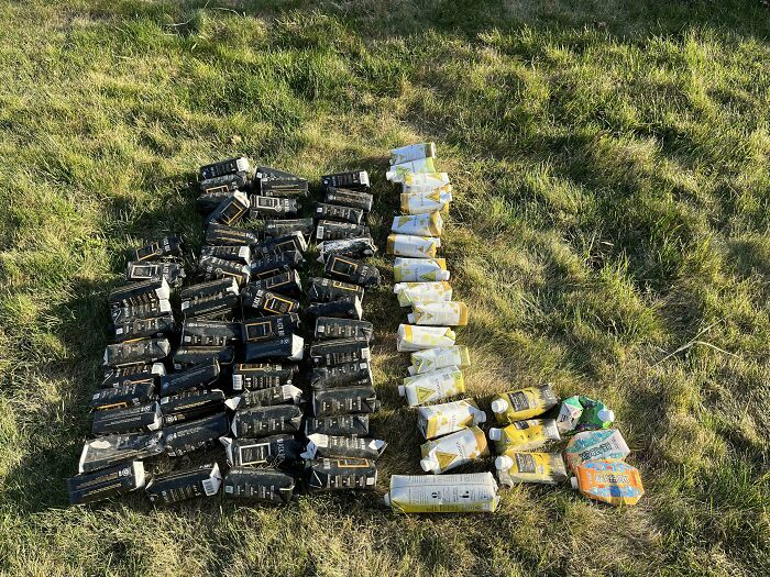 Rows of empty black and yellow tubes neatly arranged on grass, showing mildly infuriating things testing patience.