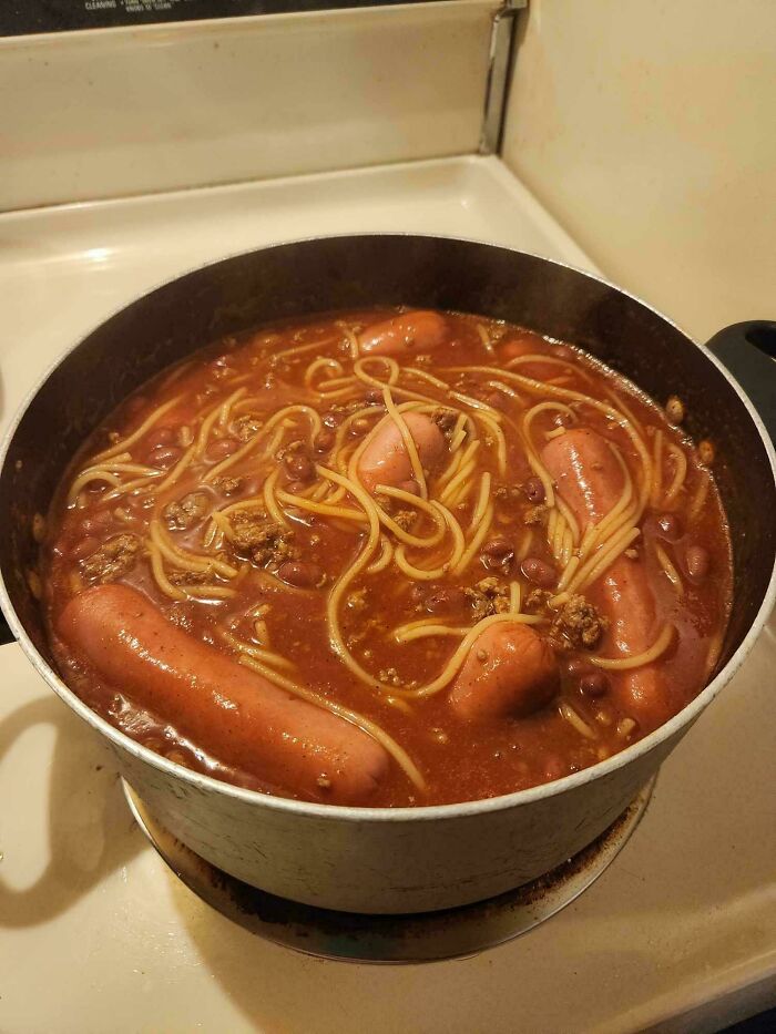 Pot of spaghetti with beans, hot dogs, and ground meat in a tomato sauce, an unholy food pic that looks unappetizing.
