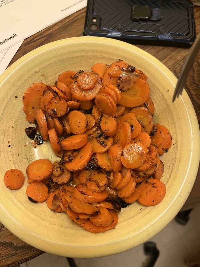 Burnt and overcooked carrot slices on a plate, an example of unholy food pics that look unappetizing.