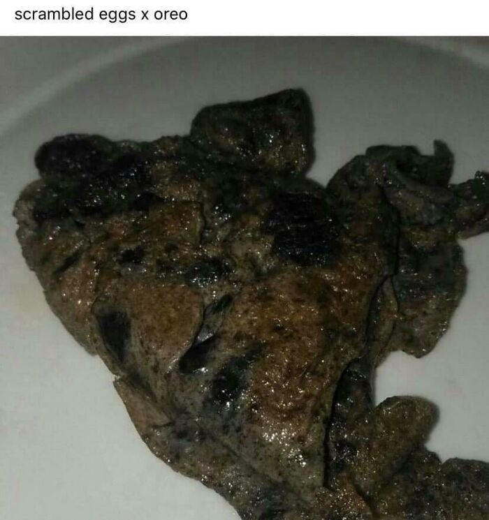 Unappetizing scrambled eggs mixed with Oreo cookies creating an unusual and unholy food combination on a white plate.