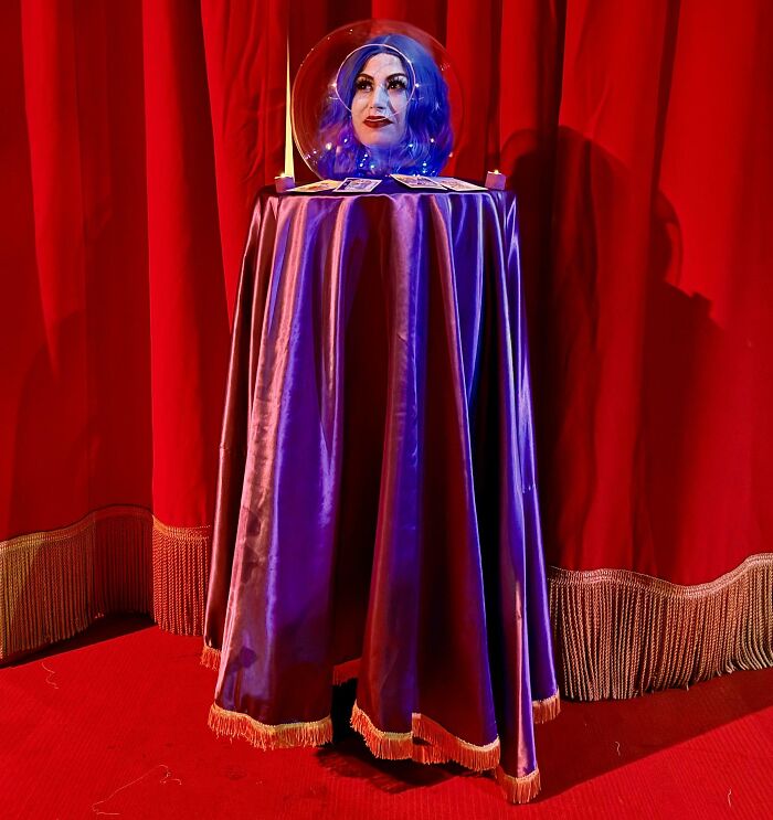 Creative Halloween costume idea featuring a person disguised as a floating head inside a crystal ball.